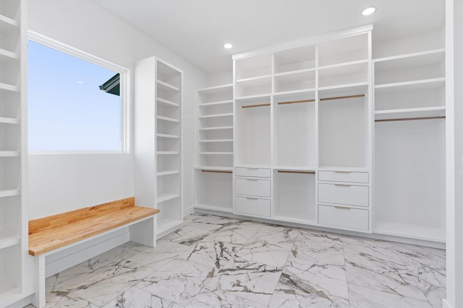 Custom shelving and abundant storage define this well-appointed closet, complemented by a convenient built-in bench and elegant flooring. Custom shelving and abundant storage define this well-appointed closet, complemented by a convenient built-in bench and elegant flooring.