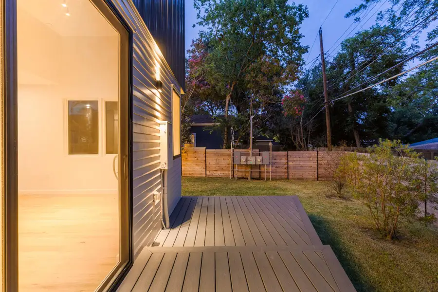 Wooden terrace with a fenced backyard