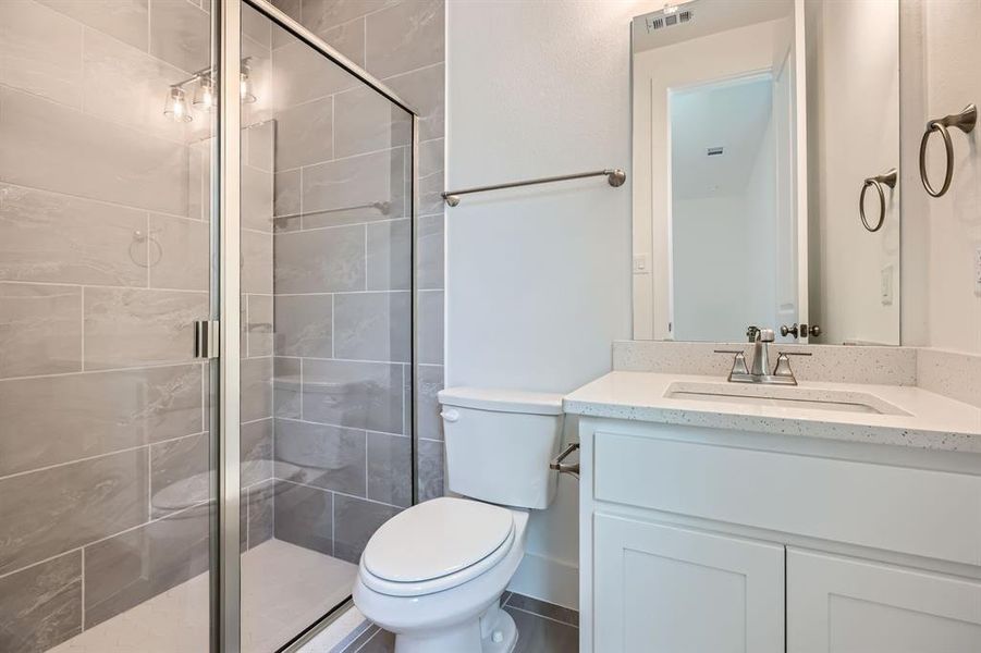 Full bath featuring toilet, vanity, and a stall shower