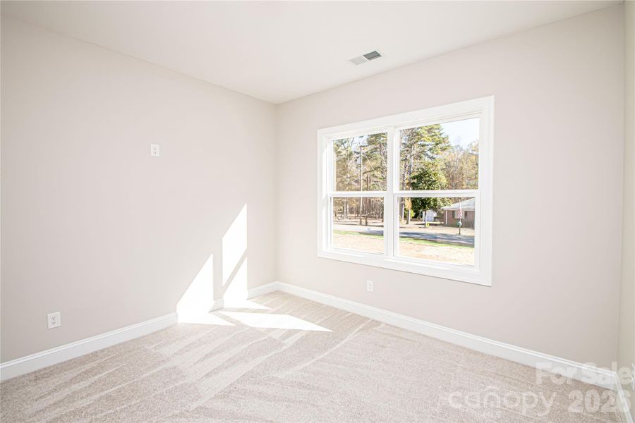 Bedroom #3 features plush carpet, a spacious closet, a large window, and an added outlet for easy ceiling fan installation.