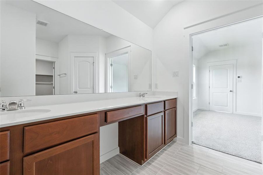 Full bath with double vanity and light colored carpet