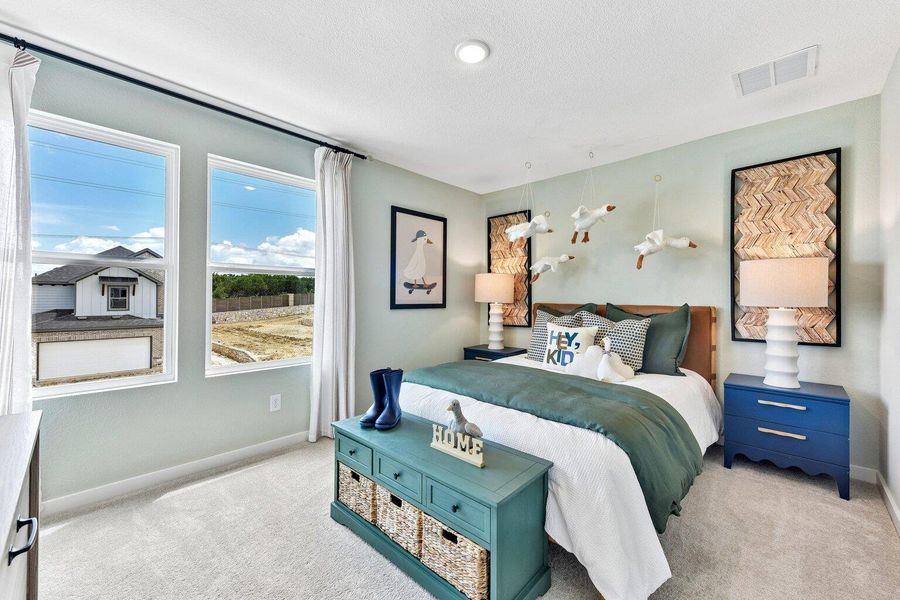 Natural light streams through tall windows onto the carpeted floor of this cozy bedroom. Natural light streams through tall windows onto the carpeted floor of this cozy bedroom.