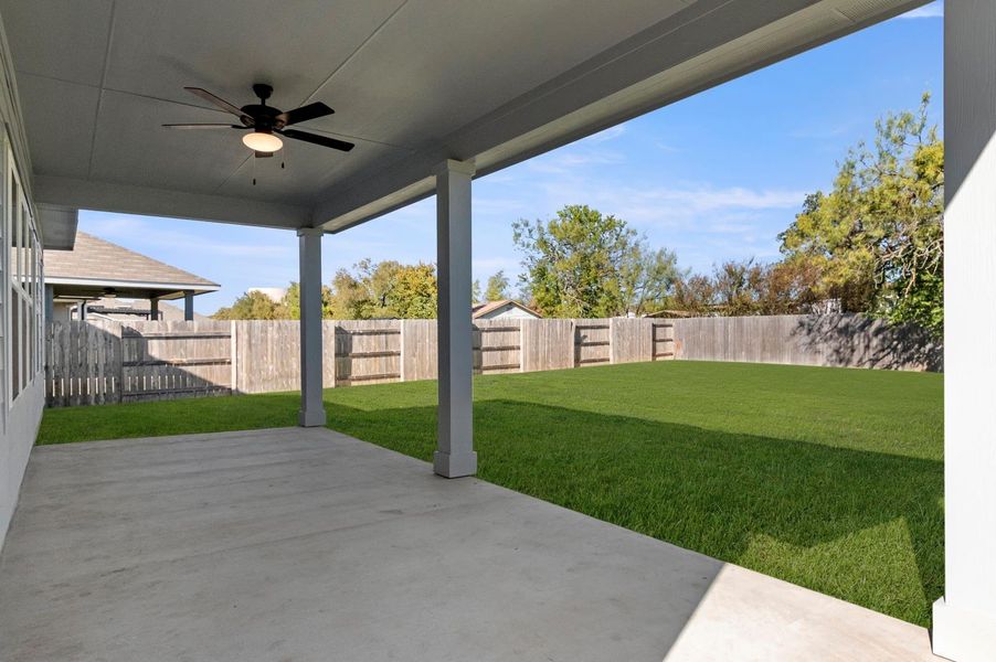 Fenced backyard featuring a ceiling fan and a patio area Fenced backyard featuring a ceiling fan and a patio area