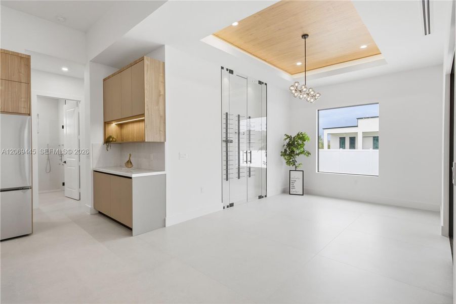 Formal dining area is highlighted by an impressive glass-enclosed wine display, adding a sophisticated focal point for entertaining! Formal dining area is highlighted by an impressive glass-enclosed wine display, adding a sophisticated focal point for entertaining!