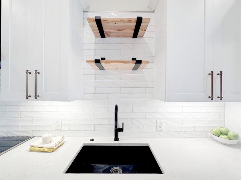 Kitchen view of white cabinetry, custom quartz countertops, and white boutique subway backsplash, custsom open shelves of antique virgin pine secured by industrial farm brackets.