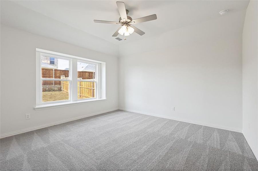 Empty room featuring light colored carpet and a ceiling fan