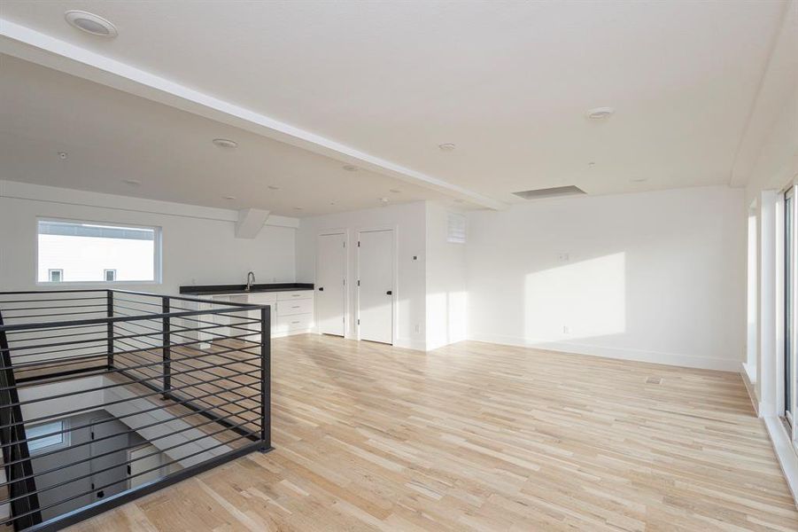 Spare room with light wood-type flooring, a wealth of natural light, and baseboards