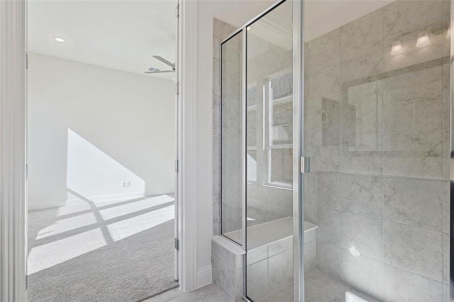 Bathroom featuring ceiling fan and a shower with shower door