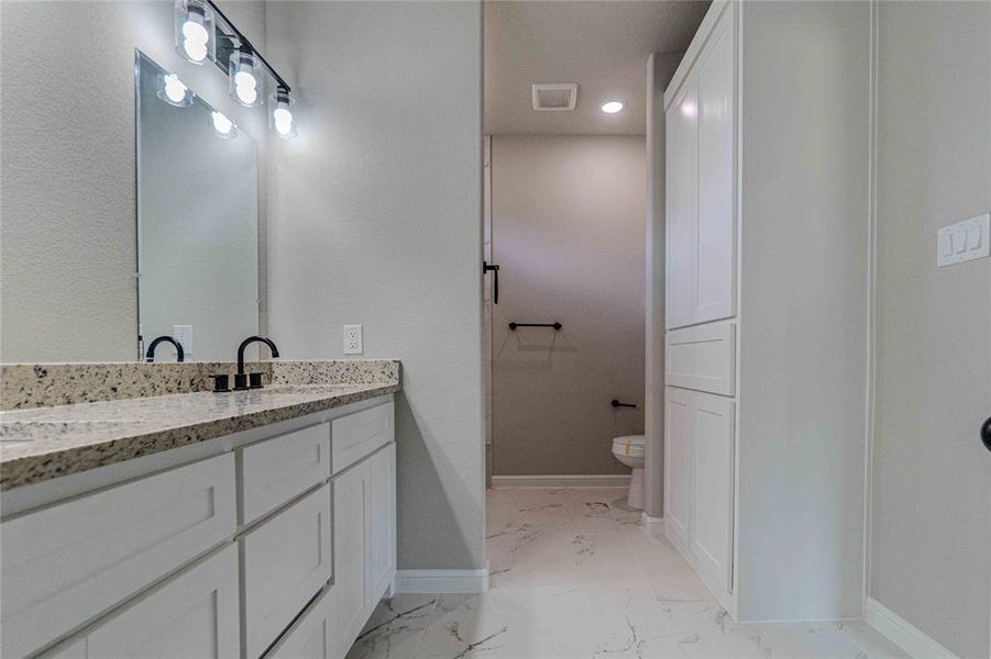 Bathroom with vanity, toilet, and tile patterned flooring