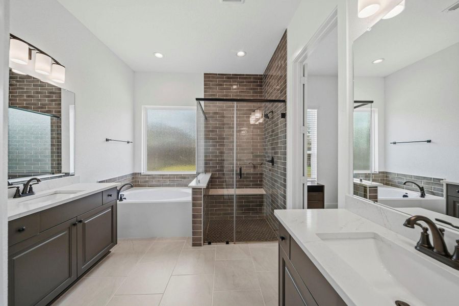 Step into comfort and style in this beautiful primary bathroom! Featuring a spacious walk-in shower with mud-set tile floors & glass surround, a serene garden tub, and dual vanities.