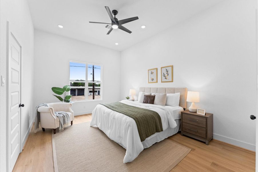 Under a high ceiling with recessed lighting, you'll fall in love with the primary bedroom suite. It offers plenty of room for a king-sized bed as well as plenty of other bedroom furniture.