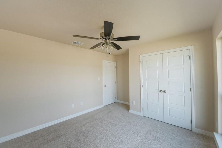 Unfurnished bedroom with carpet floors, a ceiling fan, and a closet Unfurnished bedroom with carpet floors, a ceiling fan, and a closet