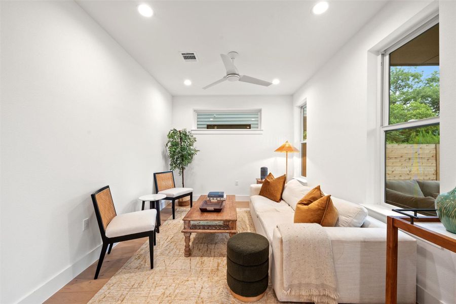 A welcoming living area/den/bedroom boasts crisp white walls, light wood flooring, and recessed lighting. A welcoming living area/den/bedroom boasts crisp white walls, light wood flooring, and recessed lighting.
