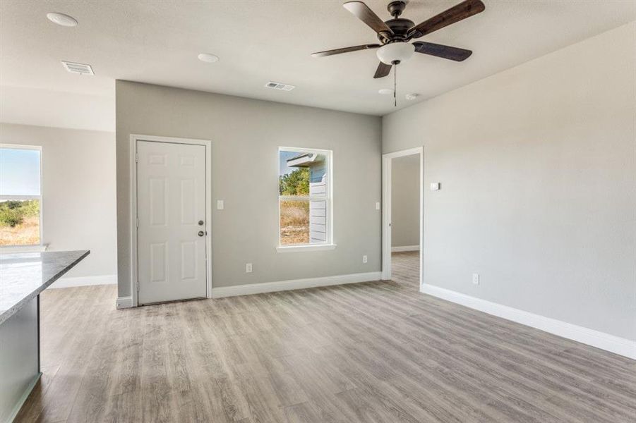 Empty room with light wood-style floors, ceiling fan, and recessed lighting