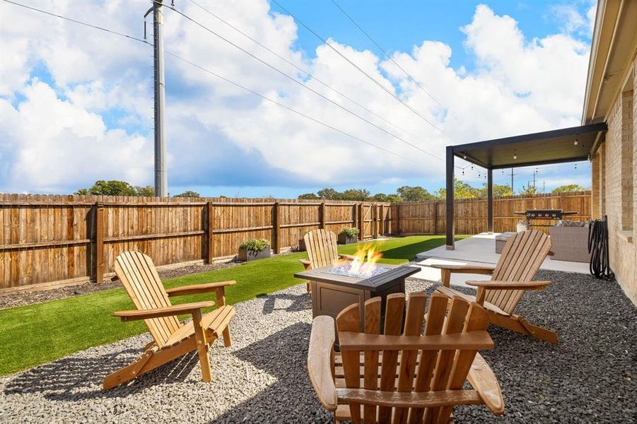Fenced backyard featuring a patio area and an outdoor fire pit Fenced backyard featuring a patio area and an outdoor fire pit