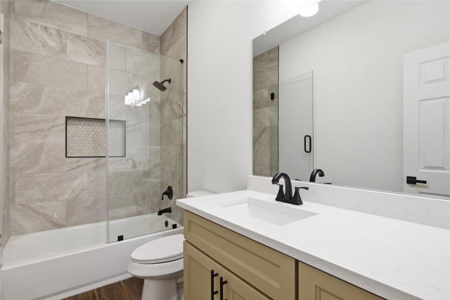 A well-appointed bathroom features a bathtub with a tiled shower surround and a single vanity with ample counter space. A well-appointed bathroom features a bathtub with a tiled shower surround and a single vanity with ample counter space.
