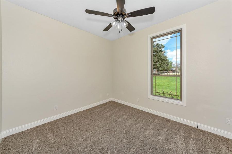 Carpeted empty room featuring ceiling fan