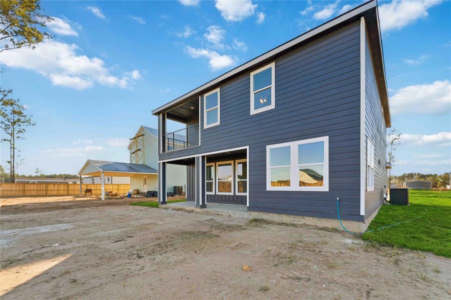 Modern two story home with sleek exterior design, covered patio, and an upstairs balcony perfect for relaxing outdoors. The spacious backyard offers endless potential for entertaining, gardening, or play. Clean lines, large windows, and a bright setting make this home both stylish and inviting.