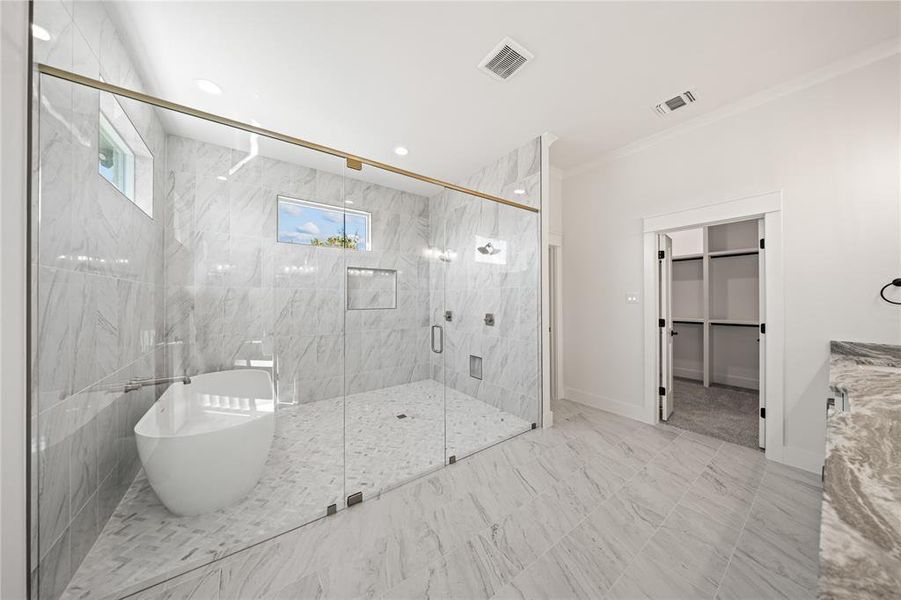 Full bathroom with a freestanding tub, vanity, a spacious closet, a marble finish shower, and crown molding