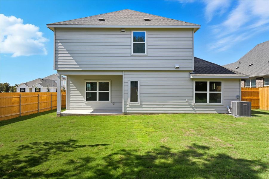 Back of house with a fenced backyard, a patio, and a shingled roof Back of house with a fenced backyard, a patio, and a shingled roof