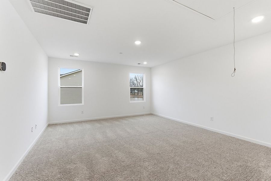 A room with a carpet and a window.