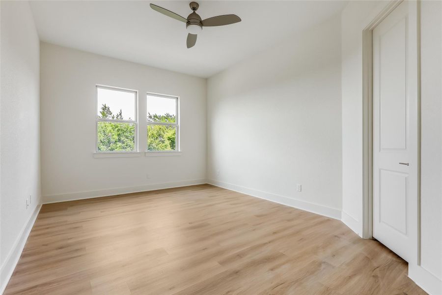 Empty room with light wood-style flooring and a ceiling fan