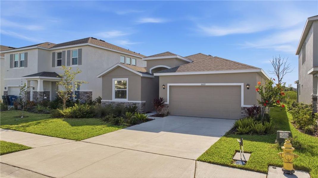 Front exterior of a new home in Bella Lago, Parrish, FL, highlighting curb appeal (Image 24). Front exterior of a new home in Bella Lago, Parrish, FL, highlighting curb appeal (Image 24).