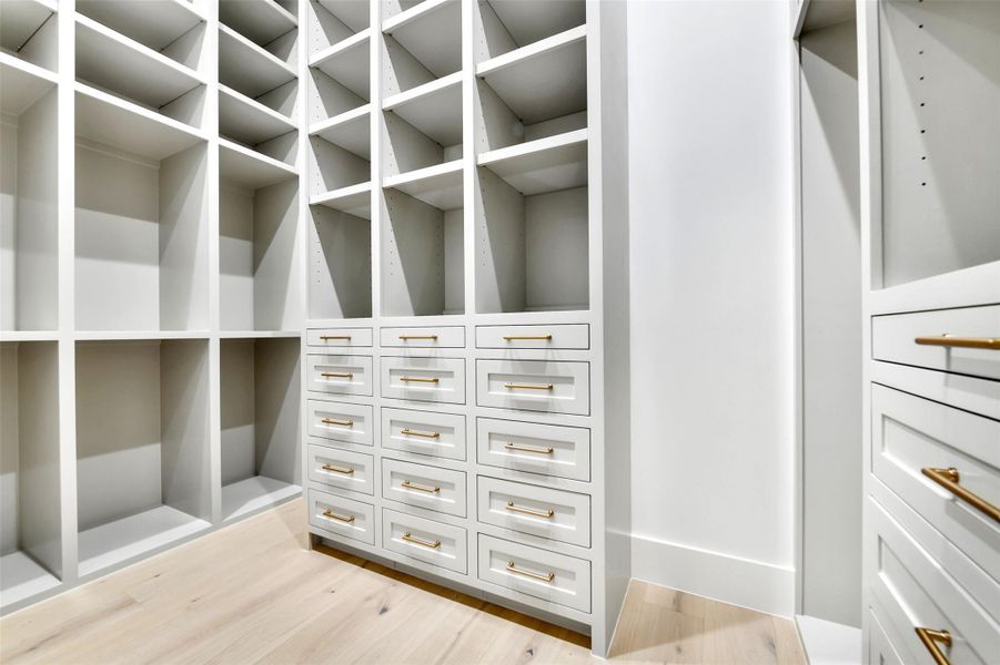 The walk in closet displays artisan crafted cabinets and built ins. Stunning asset with a plethora of space. Example image of builders craftsmanship The walk in closet displays artisan crafted cabinets and built ins. Stunning asset with a plethora of space. Example image of builders craftsmanship