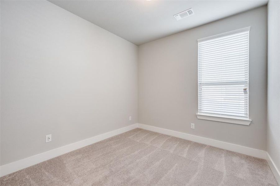 Spare room featuring light carpet and baseboards