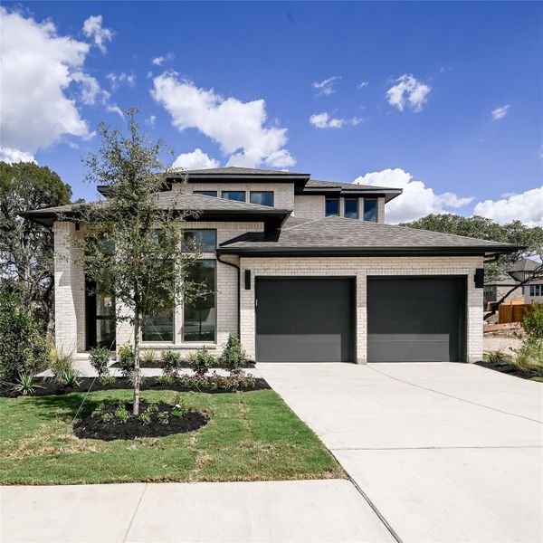 Prairie-style house featuring brick siding, driveway, a garage, and a front yard Prairie-style house featuring brick siding, driveway, a garage, and a front yard