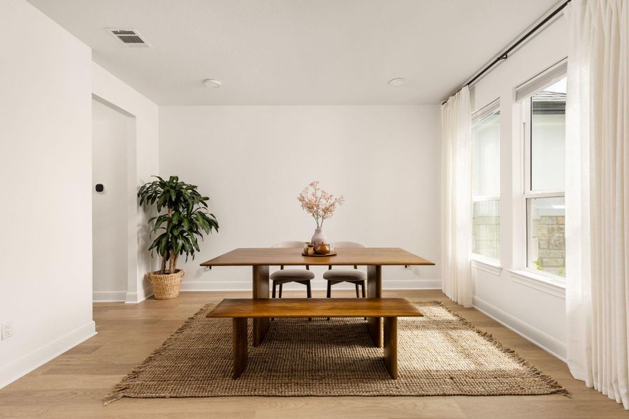 Spacious room featuring multiple large windows, wood-finish flooring, recessed lighting, and crisp white walls
