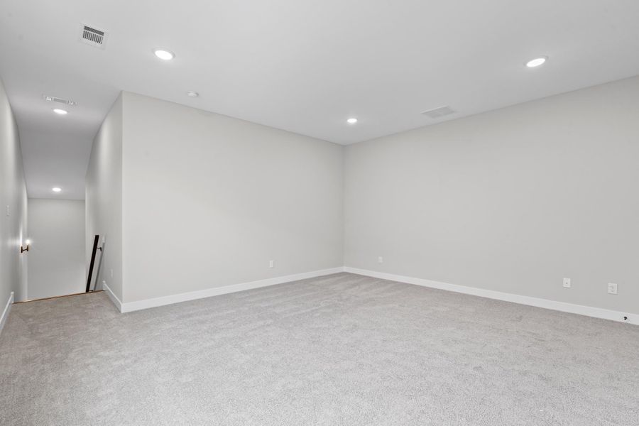 Empty room featuring recessed lighting and light colored carpet Empty room featuring recessed lighting and light colored carpet