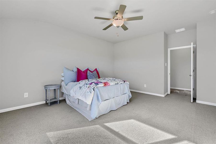 Carpeted bedroom featuring ceiling fan