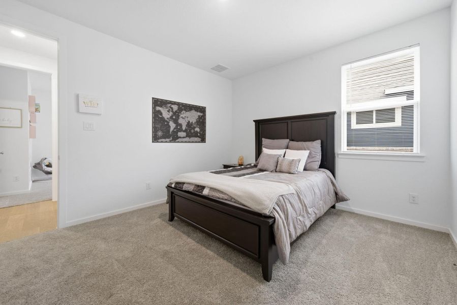 Bedroom with light colored carpet and baseboards