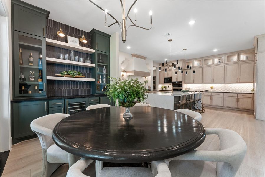 The butler’s pantry adds a high impact service area with dark cabinetry, floating shelves, and a statement backsplash. It creates a natural staging zone between dining and kitchen spaces.