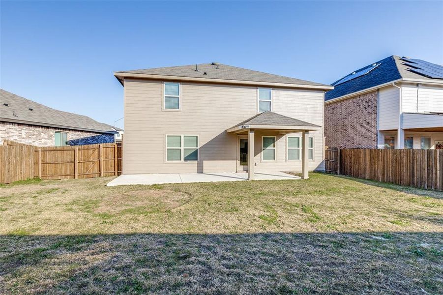 Rear view of property with a yard and a patio