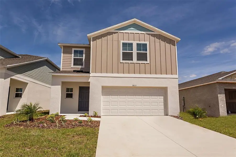 Front exterior of a new home in Two Rivers, Zephyrhills, FL, highlighting curb appeal (Image 2). Front exterior of a new home in Two Rivers, Zephyrhills, FL, highlighting curb appeal (Image 2).
