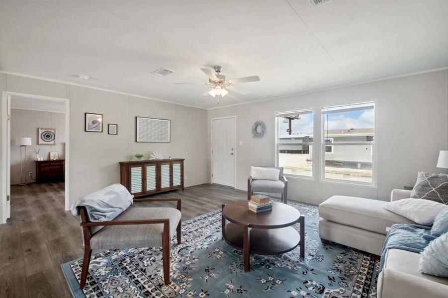 Living room with ceiling fan, crown molding, and dark hardwood / wood-style floors