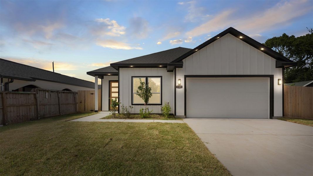 This modern home features a clean exterior with a two-car garage, a well-maintained lawn, and a welcoming entryway. Perfect for contemporary living.
