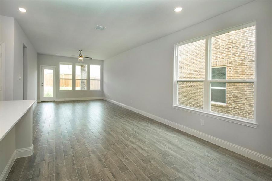 Unfurnished living room with baseboards, dark wood-style flooring, a ceiling fan, and recessed lighting Unfurnished living room with baseboards, dark wood-style flooring, a ceiling fan, and recessed lighting