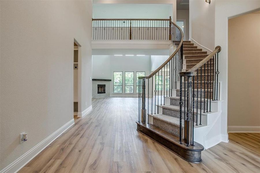 Foyer with a towering ceiling and light hardwood / wood-style flooring