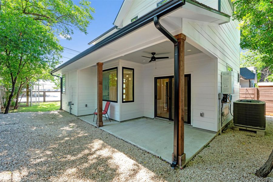 Expansive outdoor patio with wood-finish support columns and a built-in ceiling fan, zero landscape and a fully fenced for privacy. Expansive outdoor patio with wood-finish support columns and a built-in ceiling fan, zero landscape and a fully fenced for privacy.