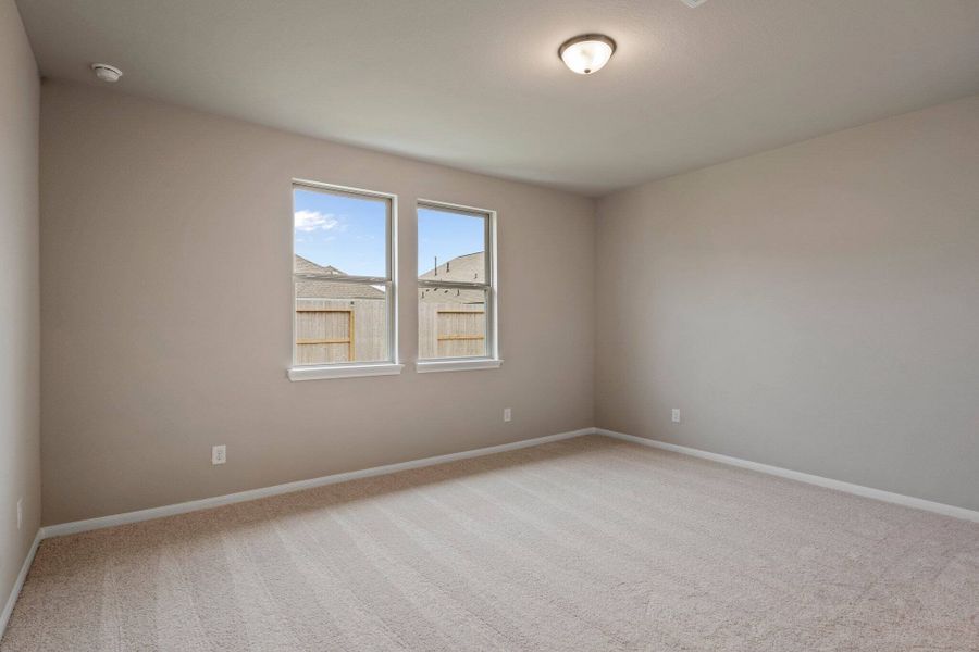 The primary bedroom is generously sized, creating a tranquil and spacious retreat that offers ample room for relaxation. Featuring plush carpet, high ceilings, fresh paint, and large windows that lets in natural lighting throughout the day.