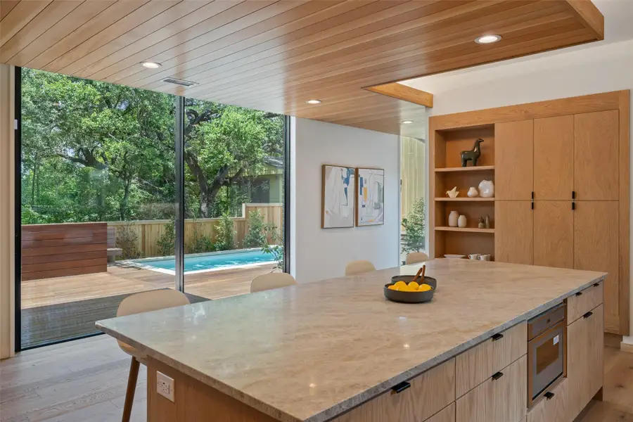 Kitchen with light brown cabinetry, light wood-style floors, a center island, modern cabinets, and wood ceiling