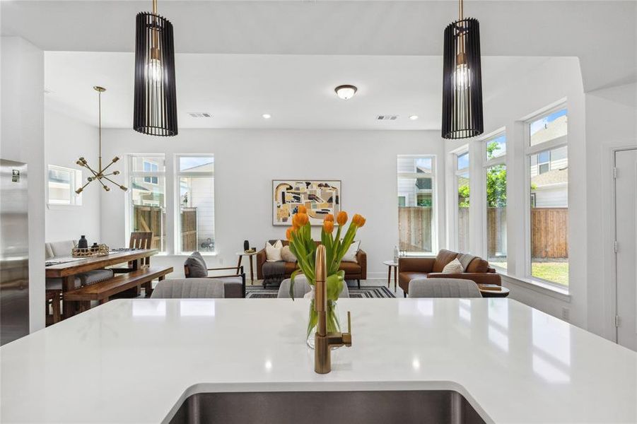 Kitchen with open floor plan, pendant lighting, light stone countertops, recessed lighting, and an island with sink Kitchen with open floor plan, pendant lighting, light stone countertops, recessed lighting, and an island with sink