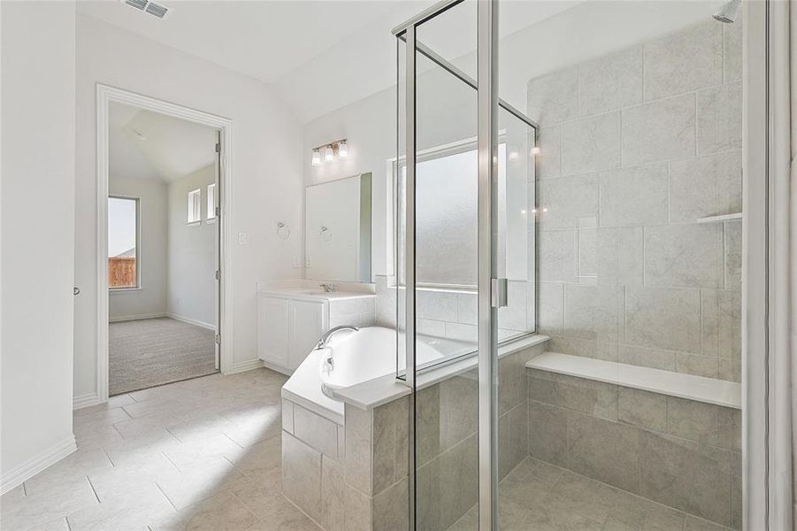 Bathroom featuring shower with separate bathtub, tile patterned floors, and vanity