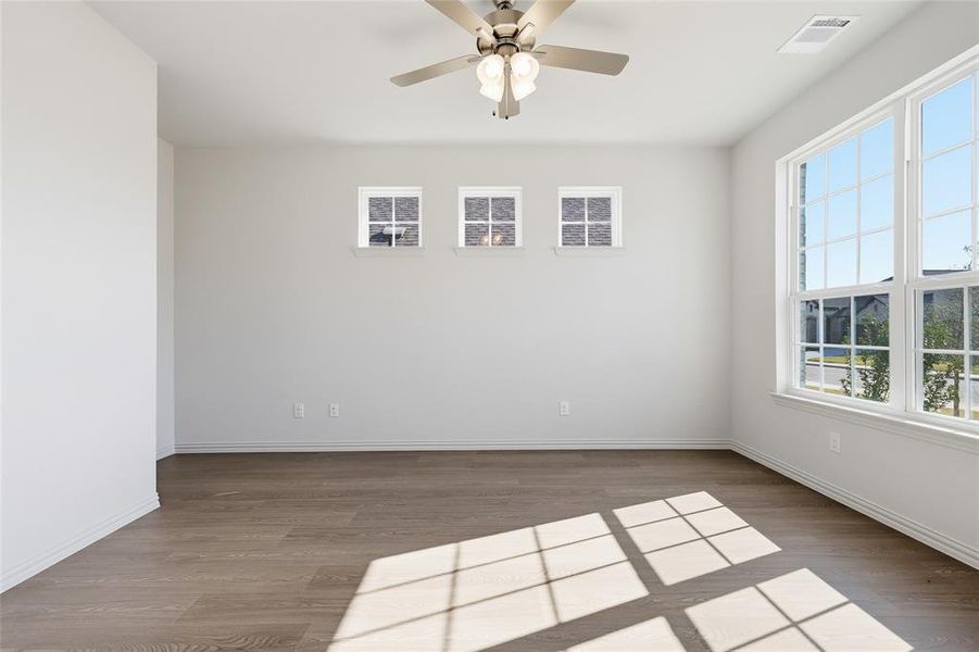 Empty room featuring dark wood-style flooring and ceiling fan Empty room featuring dark wood-style flooring and ceiling fan