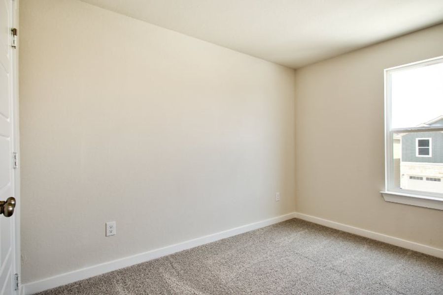 A room with a carpet and a window.