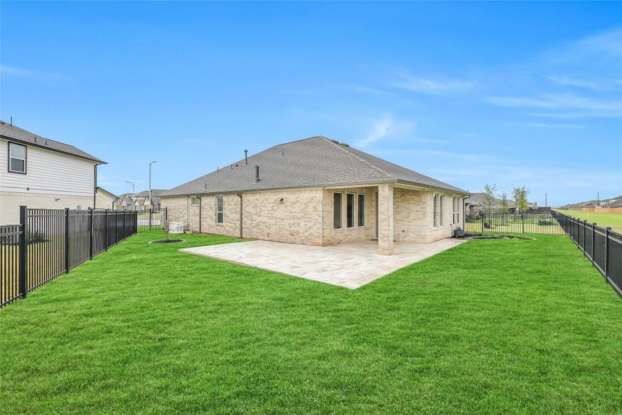 Spacious grassy yard framed by clean fencing and open skies, offering plenty of room for outdoor activities or future landscape enhancements.
