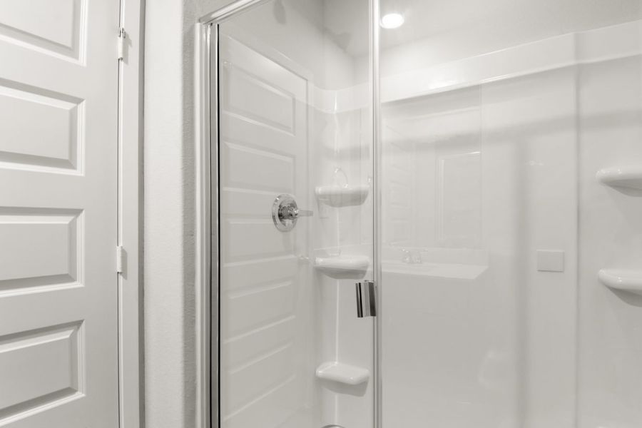 Image of a primary bathroom with a white vinyl walk-in shower